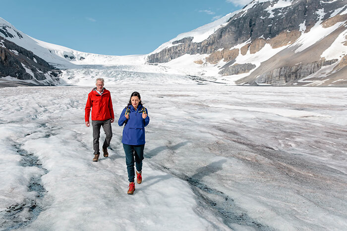 Couple walking on glacier