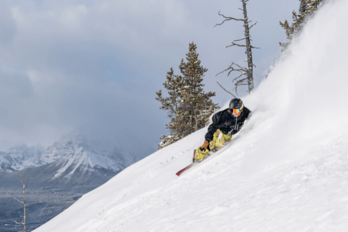 person skiing down steep mountain slope