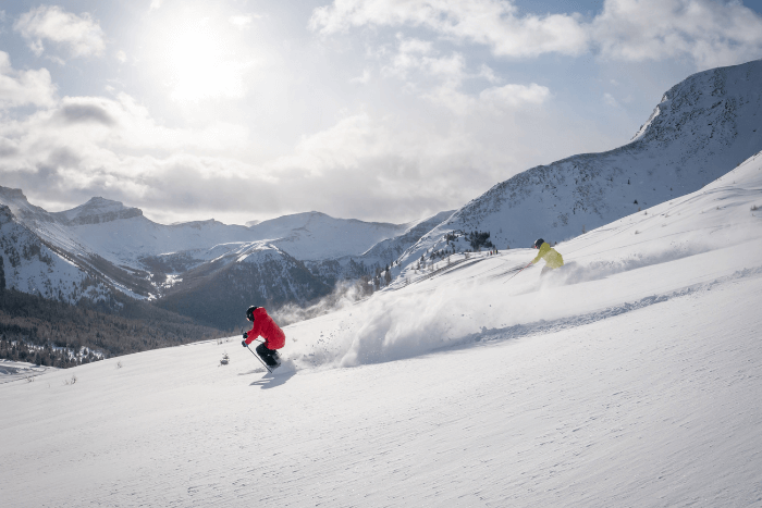 two people skiing down a mountain